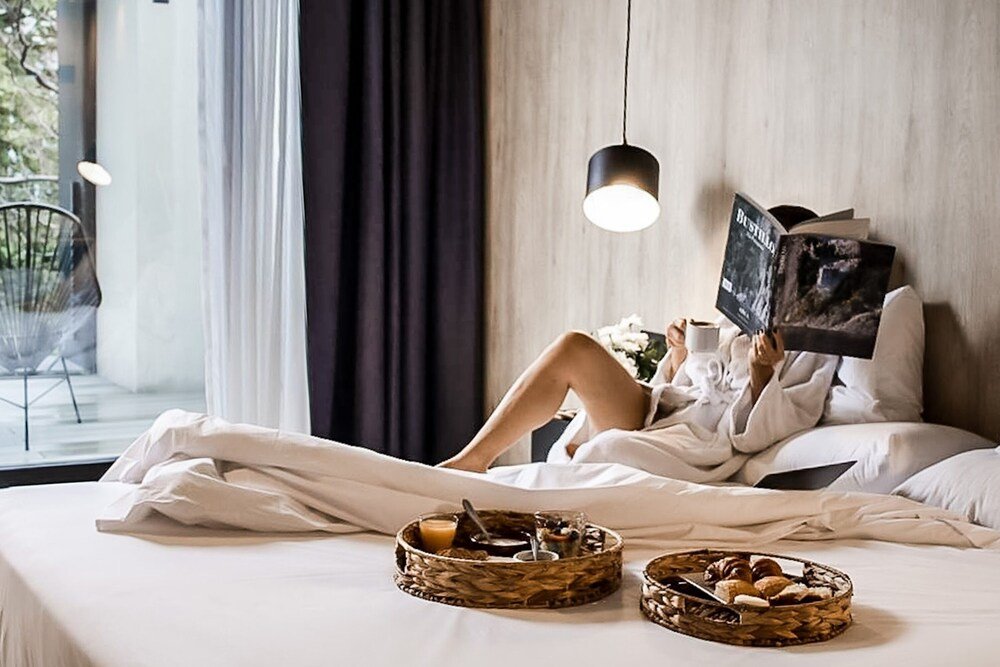 Guest lying on a bed in a room at Krista Boutique Hotel