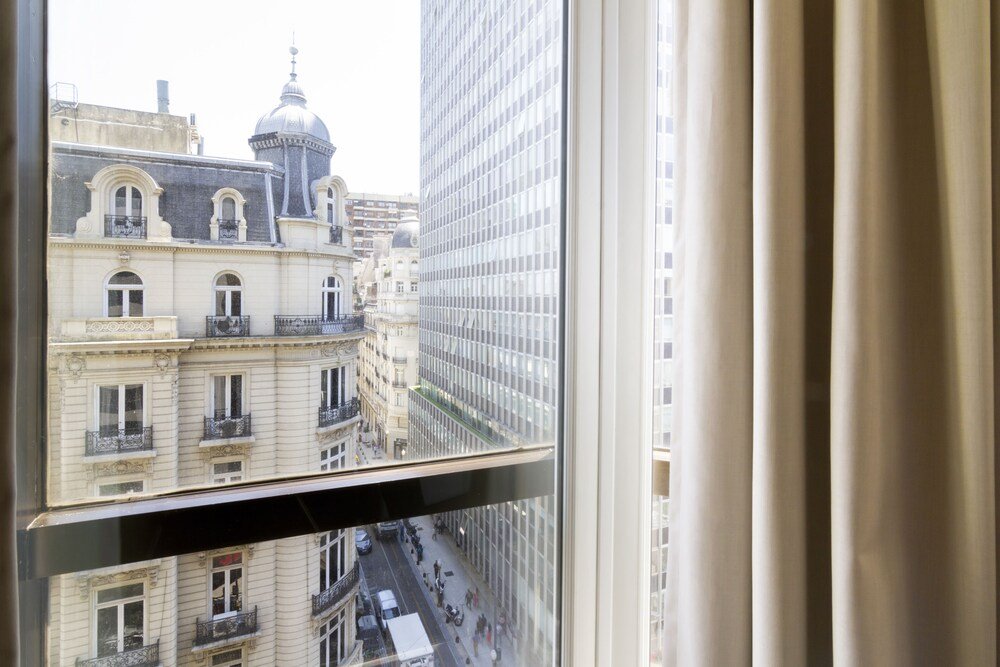 View through a hotel window with curtains in central Retiro