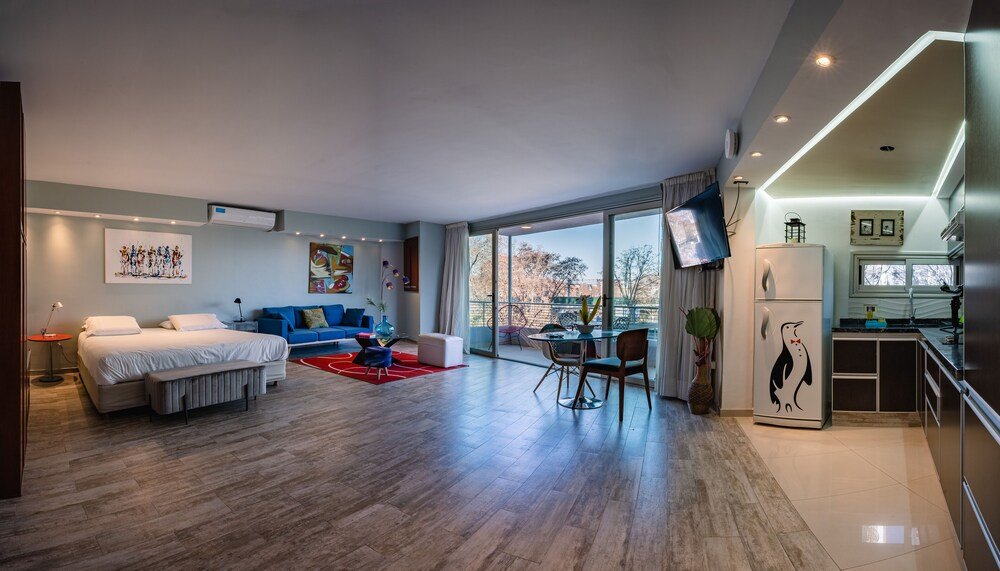 Hotel room with a large bed, sofa, dining area and kitchen